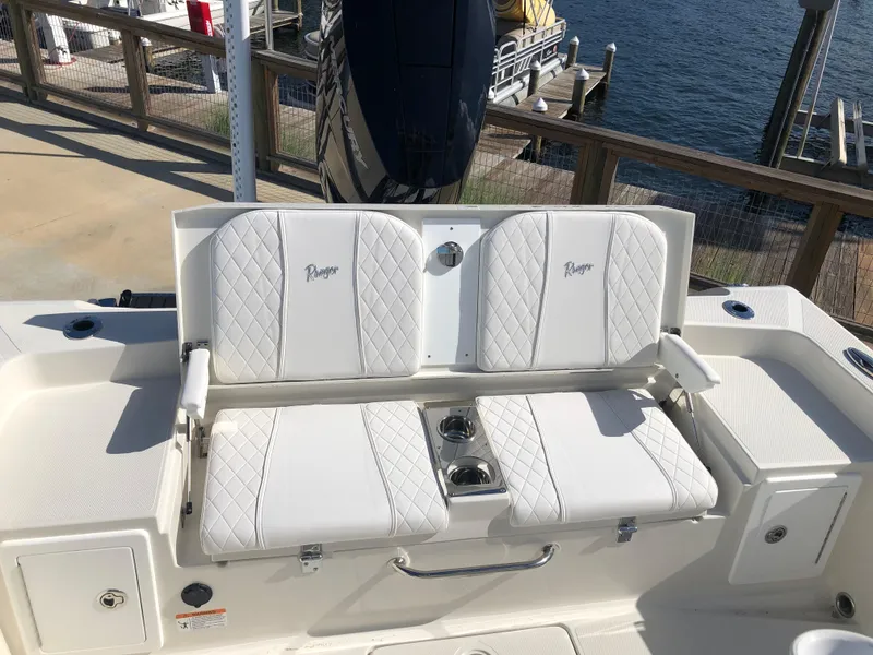 Slide: The Image of Ranger 2660 boat seating, 2025 model, with white quilted upholstery by the dock. - 19