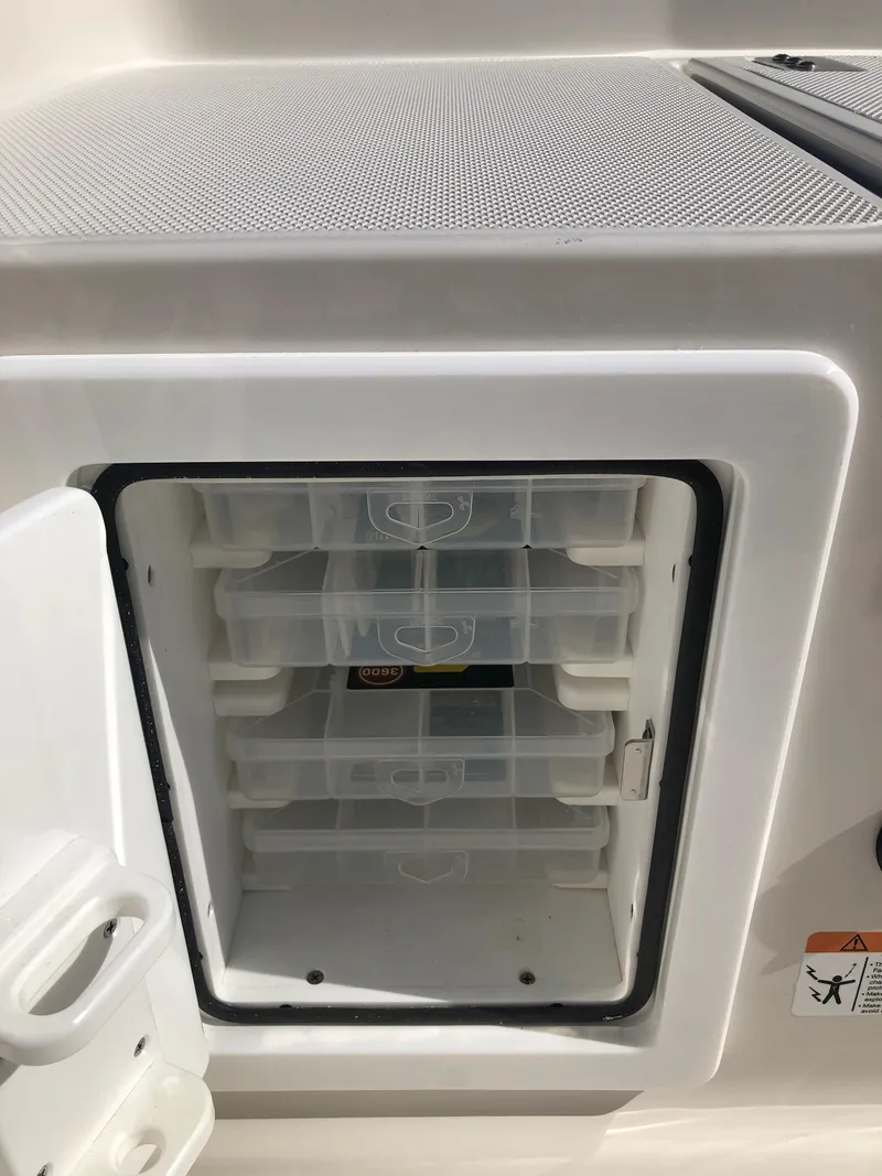 Slide: The Image of Ranger 2660 boat storage compartment with organized tackle boxes, 2025 model. - 21