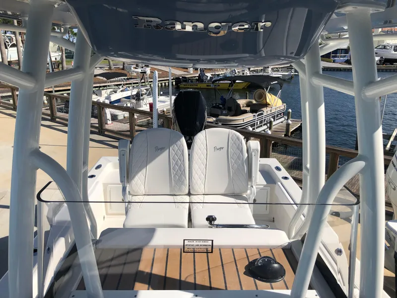 Slide: The Image of Ranger 2660 boat interior, 2025 model, with white seating and wooden deck at a marina. - 35