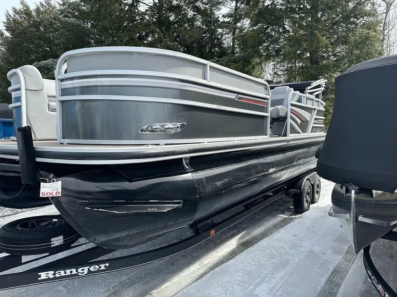 Slide: The Image of 2021 Ranger 243C pontoon boat on trailer, sold, in outdoor setting. - 7