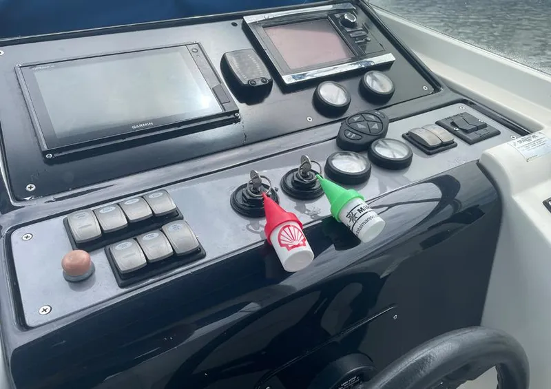 Slide: The Image of Control panel of a 1999 Custom 42 boat with navigation screens and switches. - 12