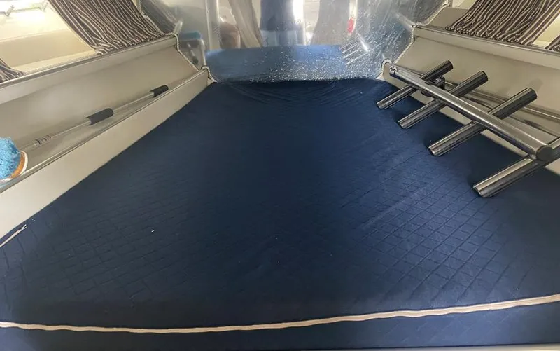 Slide: The Image of Interior of a 1999 Custom 42 boat with blue bedding and rod holders. - 13