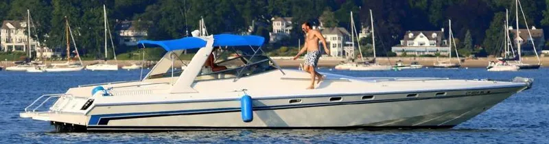 Slide: The Image of Custom 42 boat, 1999 model, cruising on a scenic lake with blue canopy. - 4