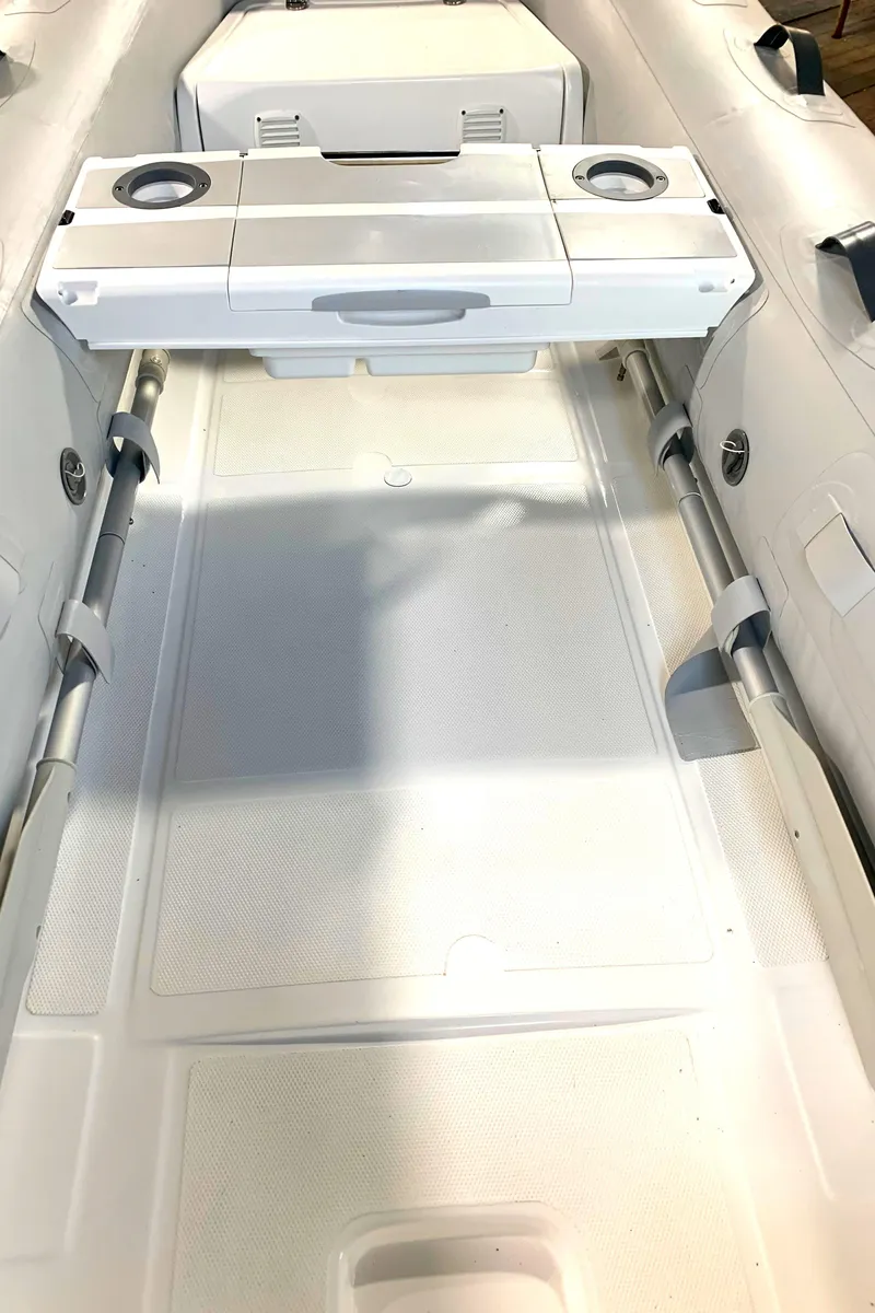 Slide: The Image of 2023 Walker Bay Supertender 325 Deluxe interior with seating and storage compartments. - 2