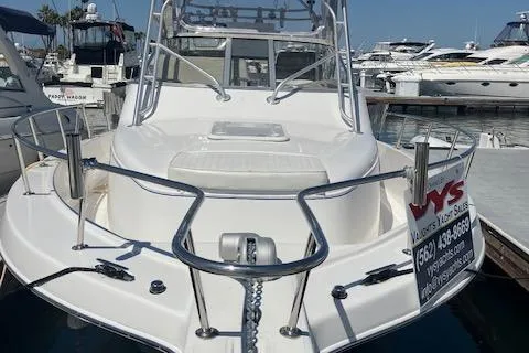 Slide: The Image of 2004 Pro-Line 30 WALK boat docked at marina, featuring sleek design and stainless steel railings. - 2