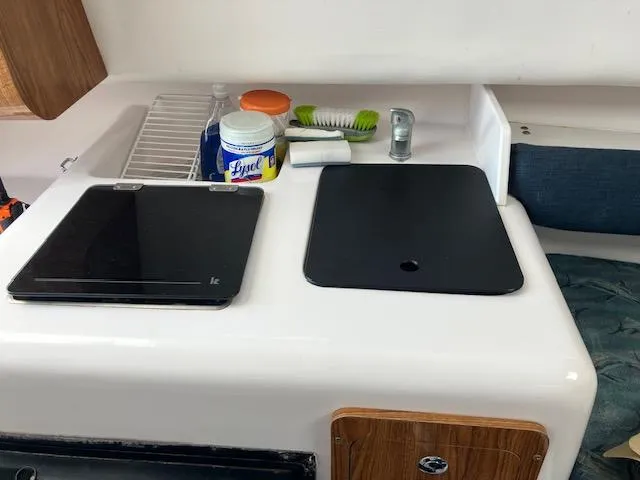 Slide: The Image of 2004 Pro-Line 30 WALK boat interior with kitchenette, featuring stove and cleaning supplies. - 5