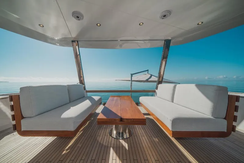 Slide: The Image of Azimut Magellano 25 Metri 2023 yacht deck with ocean view, modern seating, and wooden table. - 12