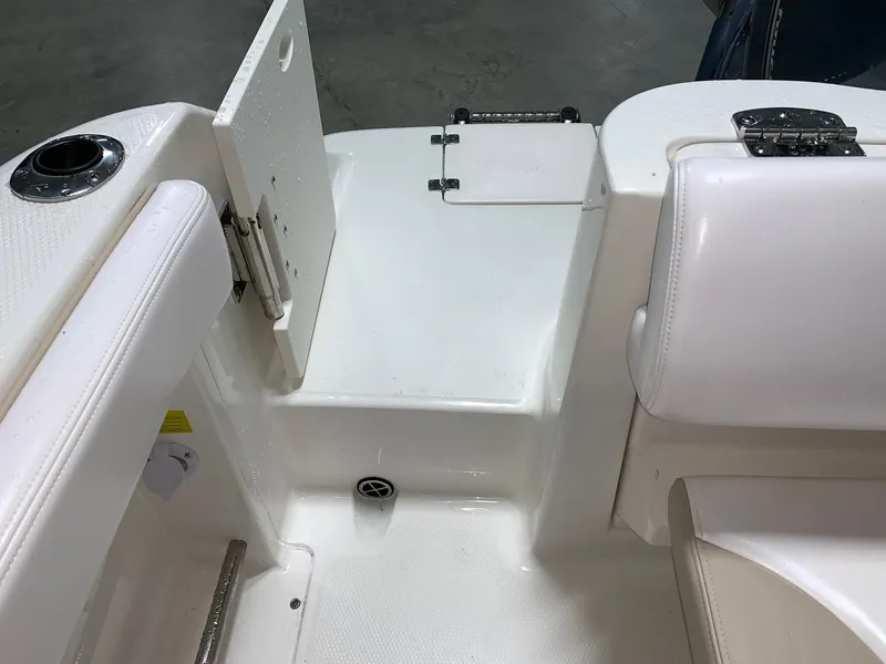 Slide: The Image of 2026 Robalo R222 Center Console boat interior, featuring white seating and storage compartments. - 11