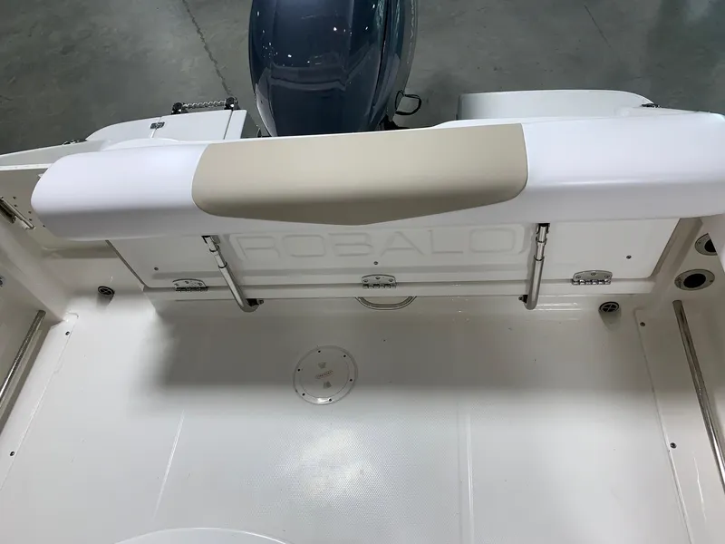 Slide: The Image of 2026 Robalo R222 Center Console boat interior with cushioned seating and engine view. - 13
