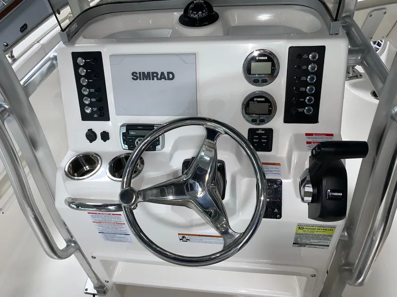 Slide: The Image of 2026 Robalo R222 Center Console dashboard with Simrad display and steering wheel. - 17