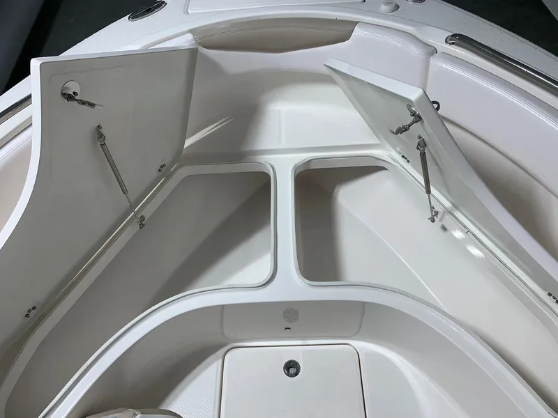 Slide: The Image of 2026 Robalo R222 Center Console boat storage compartments open, showcasing spacious design. - 22