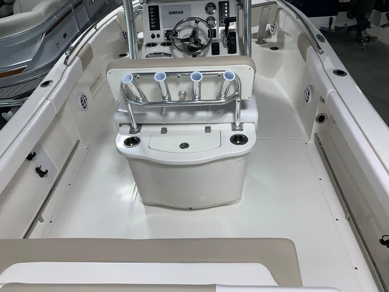 Slide: The Image of 2026 Robalo R222 Center Console boat interior with steering wheel and rod holders. - 8