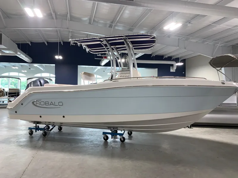 The Image of 2026 Robalo R222 Center Console boat displayed indoors on wheeled stands. - 0