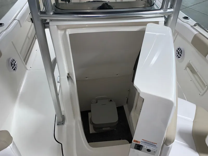 Slide: The Image of 2026 Robalo R222 Center Console boat interior with compact marine toilet. - 18