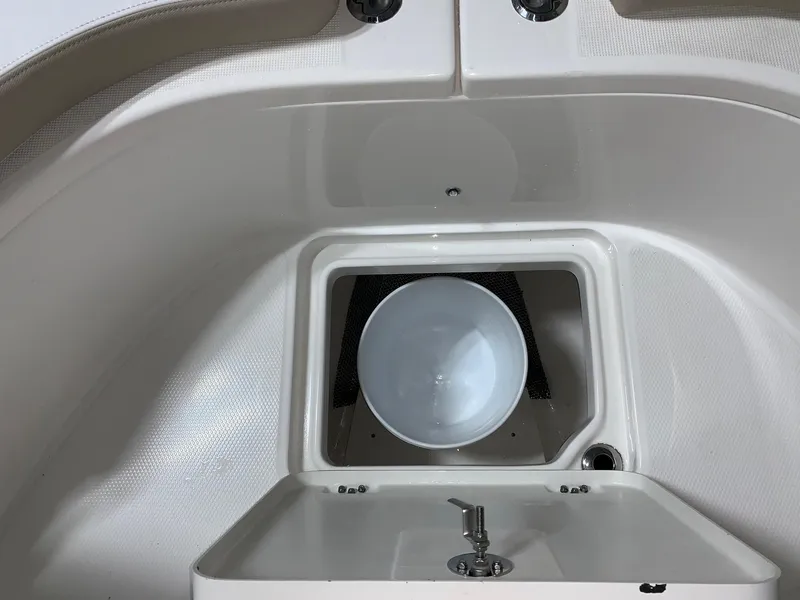 Slide: The Image of 2026 Robalo R222 Center Console boat interior with storage compartment and sink. - 20