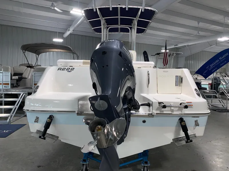 Slide: The Image of 2026 Robalo R222 Center Console boat in showroom, rear view with outboard motor. - 3