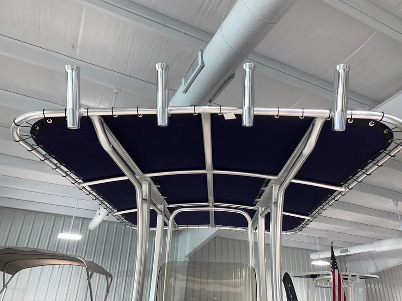 Slide: The Image of 2026 Robalo R222 Center Console T-top with rod holders in a showroom. - 9