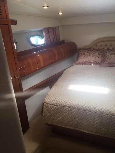 Slide: The Image of Luxurious 1997 Baia Cantieri yacht bedroom with elegant wood accents and plush bedding. - 10