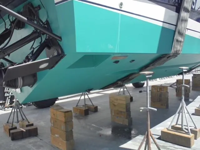 Slide: The Image of Baia Cantieri 1997 boat on blocks for maintenance, turquoise hull visible. - 20
