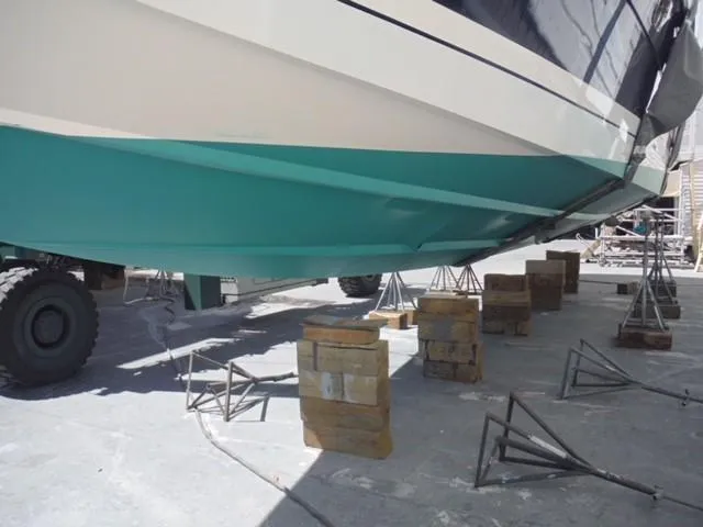 Slide: The Image of 1997 Baia Cantieri boat on stands, turquoise hull, dry dock maintenance. - 21