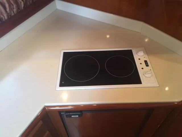 Slide: The Image of 1997 Baia Cantieri yacht kitchen with electric stovetop and wooden cabinetry. - 9