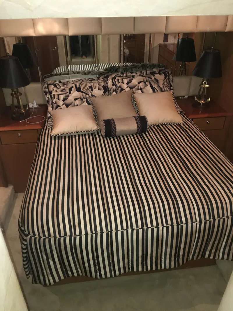 Slide: The Image of Luxurious bedroom in 2001 Ocean Yachts 56 Super Sport with striped bedding and elegant decor. - 28