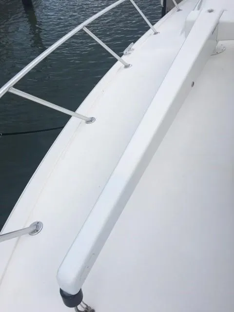 Slide: The Image of 2001 Ocean Yachts 56 Super Sport deck with railing, docked by the water. - 47