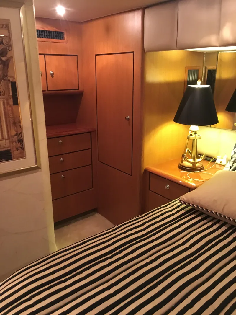 Slide: The Image of Cozy cabin interior of 2001 Ocean Yachts 56 Super Sport with striped bedding and warm lighting. - 31