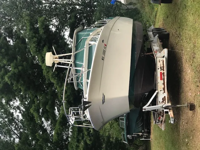 Slide: The Image of 1969 Chris-Craft Commander Sedan boat on trailer, surrounded by trees. - 2