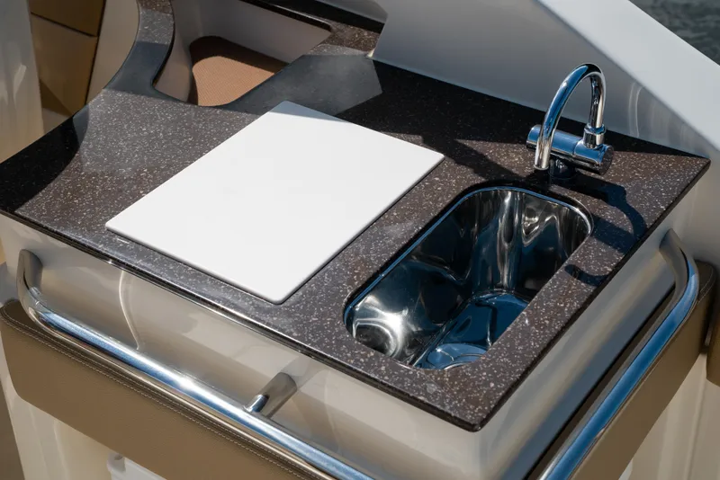 Slide: The Image of Scout 240 Dorado 2026: Sleek onboard kitchen with sink and cutting board. - 29