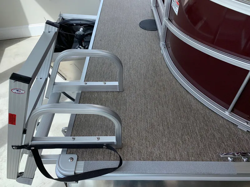 Slide: The Image of 2024 Starcraft LX22 R pontoon boat with aluminum ladder and carpeted deck. - 15