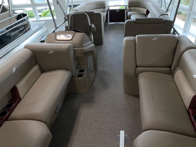 Slide: The Image of 2024 Starcraft LX22 R pontoon boat interior with beige seating and helm station. - 4