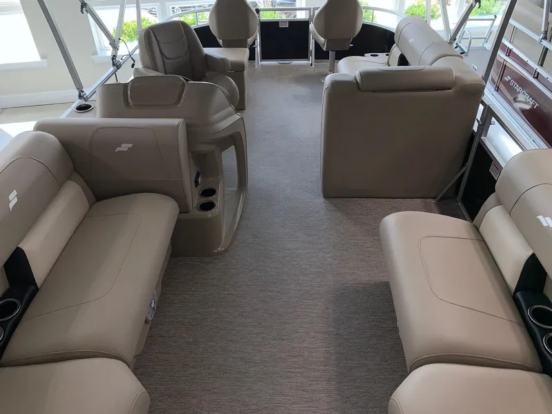 Slide: The Image of 2024 Starcraft LX20 F pontoon boat interior with beige seating and spacious layout. - 5