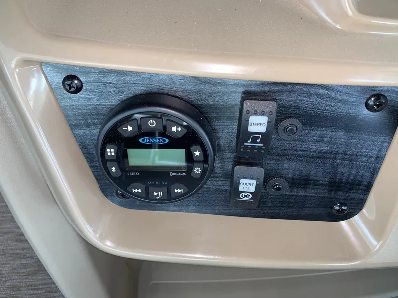 Slide: The Image of 2024 Starcraft LX20 F boat control panel with Jensen stereo system and switches. - 10