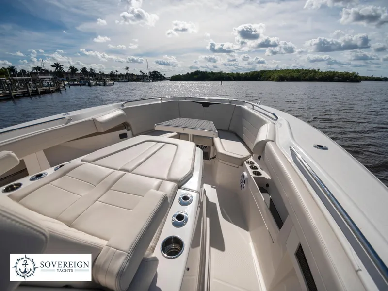 Slide: The Image of 2024 Sailfish 360 CC boat interior with luxurious seating and cup holders on a sunny day. - 33