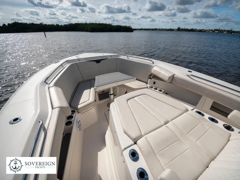 Slide: The Image of 2024 Sailfish 360 CC boat interior with seating and table on calm water. - 38