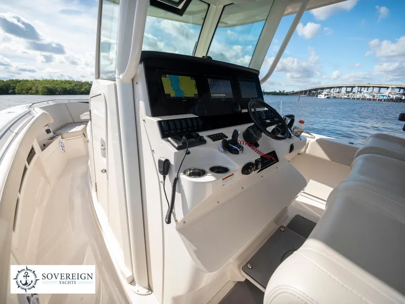 Slide: The Image of 2024 Sailfish 360 CC boat console with navigation equipment and scenic water view. - 48