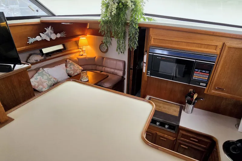 Slide: The Image of Interior of 1989 Carver 42 Aft Cabin Motor Yacht with cozy seating and kitchen area. - 6