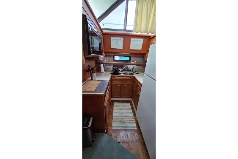 Slide: The Image of Compact kitchen in 1989 Carver 42 Aft Cabin Motor Yacht with wood cabinetry and appliances. - 9