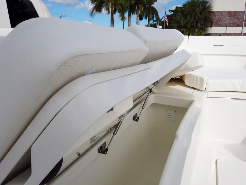 Slide: The Image of 2023 Regulator 28 boat with open storage compartment and cushioned seating. - 11