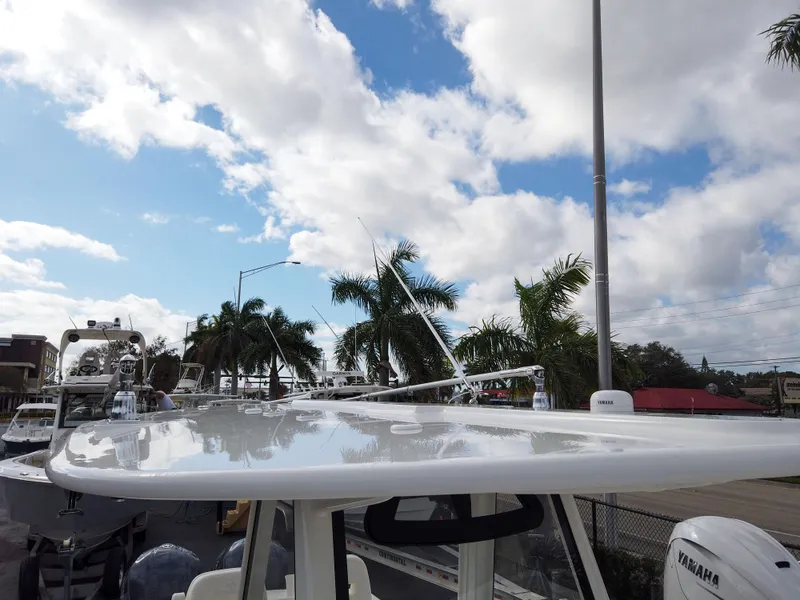 Slide: The Image of 2023 Regulator 28 boat with a clear sky and palm trees in the background. - 16