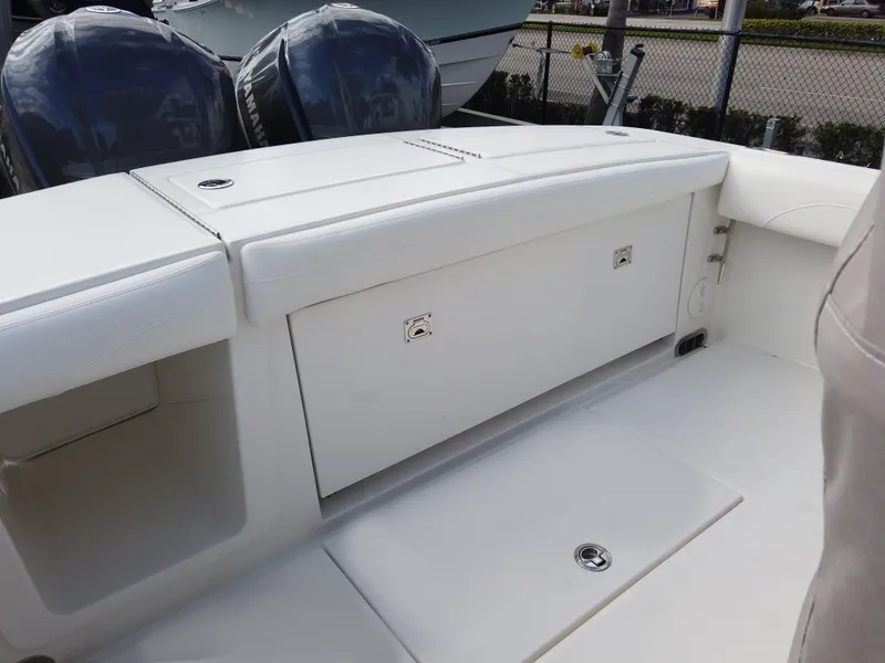 Slide: The Image of 2023 Regulator 28 boat interior with storage compartments and twin outboard motors. - 21