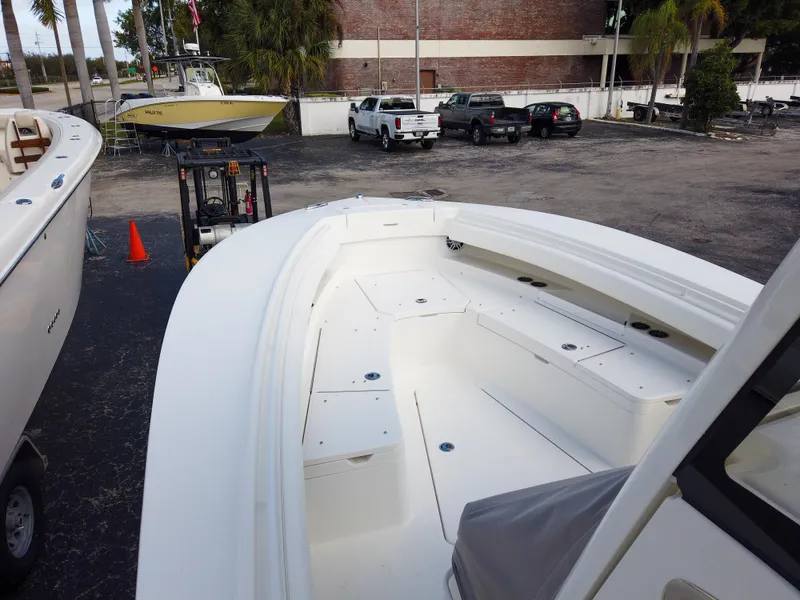 Slide: The Image of 2023 Regulator 28 boat with spacious deck and seating in a parking lot. - 27
