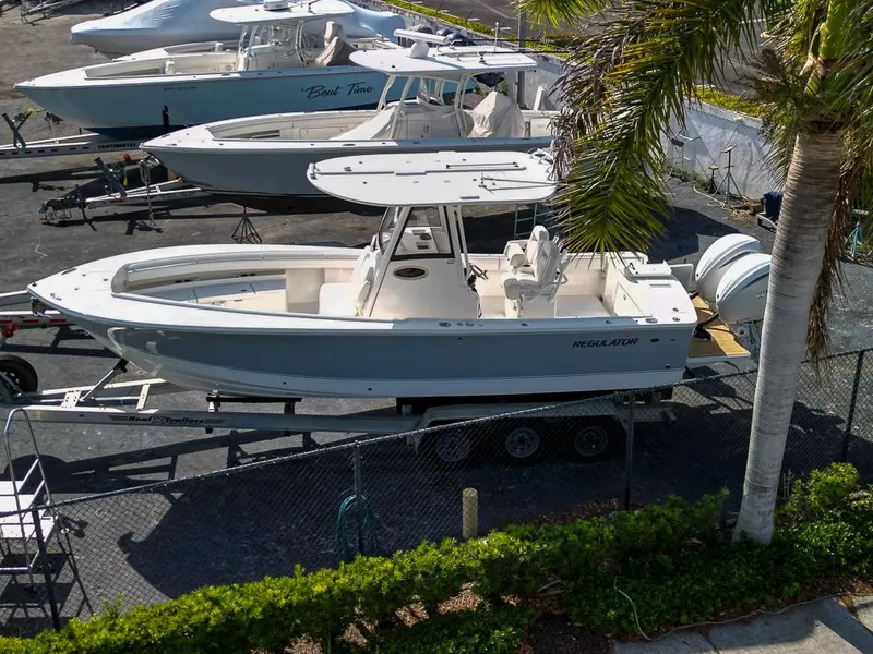 Slide: The Image of 2023 Regulator 28 boat on trailer in marina, surrounded by other boats. - 3