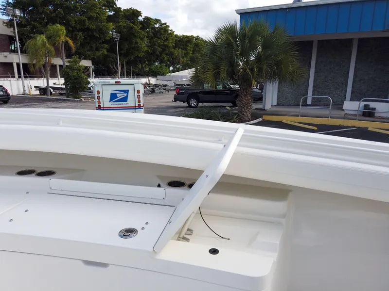 Slide: The Image of 2023 Regulator 28 boat with open storage compartment, docked near USPS truck. - 30