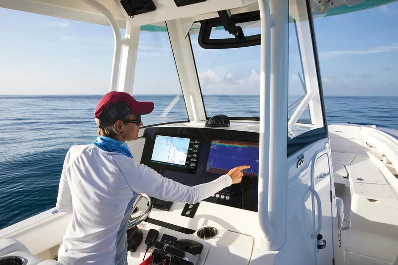 Slide: The Image of Person operating 2023 Regulator 28 boat with advanced navigation system. - 35