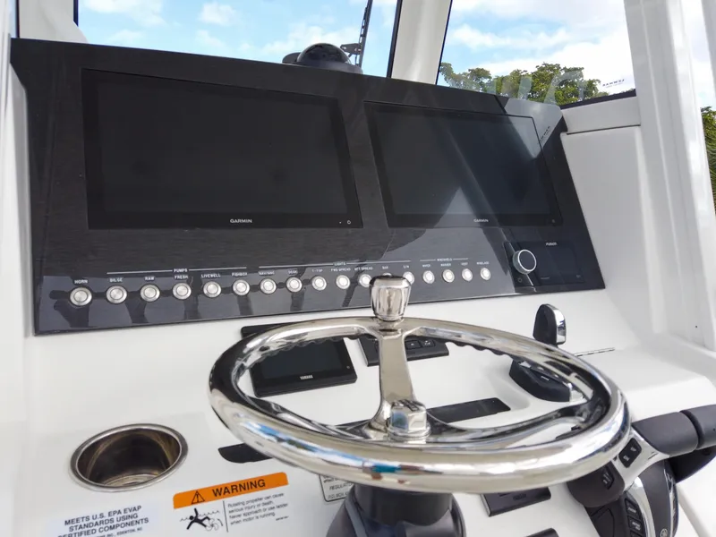 Slide: The Image of Control panel of a 2023 Regulator 28 boat with dual screens and steering wheel. - 40
