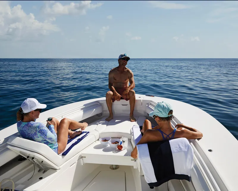Slide: The Image of People relaxing on a 2023 Regulator 28 boat in the ocean. - 9