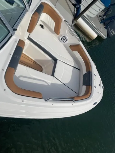 Slide: The Image of 2024 Chaparral 21 SSi boat with tan and white seating, docked on water. - 4