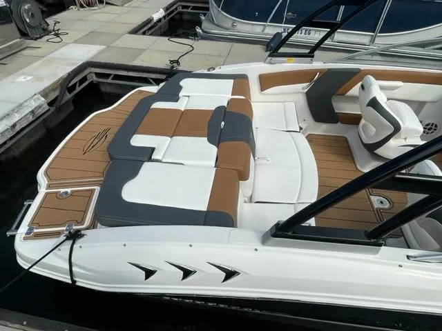 Slide: The Image of 2024 Chaparral 21 SSi boat with tan and white seating at a dock. - 5